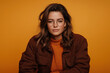 © Mselected - Portrait of a woman with glasses in a cozy sweater against a warm orange background