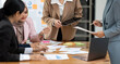 © NAMPIX - Business people having a discussion, working on laptop computer, using digital tablet a during meeting at office.