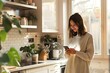 © MiswarUsaidi - Woman standing in the kitchen and using smart phone and copy space