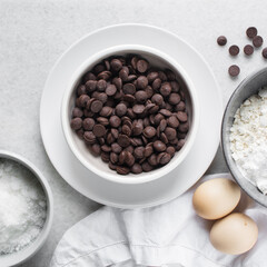 Wall Mural - overhead view of mise en place for homemade chocolate chip cookies, ingredients for making chocolate chip cookies on a marble countertop	