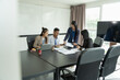 © Wanda - Asian businesswoman presents project to working group in modern office