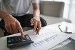 © Wanda - Man using calculator calculate finance and another hand holding pen