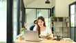 © Prathankarnpap - Asian female student working on her laptop in a modern study space