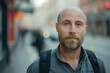 © Sascha - A man with a beard and a backpack is standing on a street