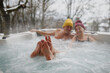 © Halfpoint - Close up on feet of senior couple bathing in hot tub during cold winter day.