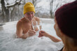 © Halfpoint - Senior couple bathing in hot tub during cold winter day, toasting with champagne. Romantic wellness getaway with spa during Valentine's weekend.
