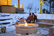 © Halfpoint - Older couple has lit a fire in garden fire pit. Seniors watching flames, relaxing and drinking hot tea.