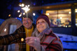 © Halfpoint - Happy senior couple celebrating new year with sparklers, enjoying winter evening.