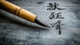 Close-up of a calligraphy brush resting on elegant Chinese characters written on dark grey paper.