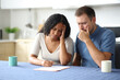 © Antonioguillem - Worried interracial couple or roommates checking contract
