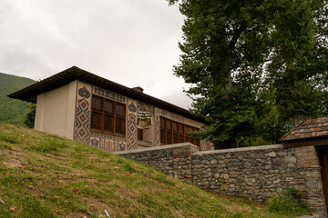 Wall Mural - A house with a stone wall and a stone fence. The house is painted in a light color