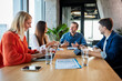 © Westend61 - Smiling business colleagues having meeting in conference room at office