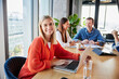 © Westend61 - Happy young businesswoman sitting with colleagues in office