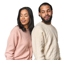 Wall Mural - Young Latino couple in studio looks aside smiling, cheerful and pleasant.