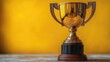 © Fotograf - A golden trophy sits atop a wooden table
