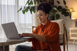 © ReeldealHD images - African american woman sitting on floor using a laptop at home