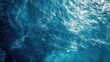 © Rizvan - Aerial view of serene blue ocean water surface with bright sunlight reflections creating an abstract backdrop ideal for text placement