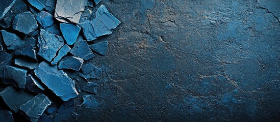 Leinwandbilder - Blue stone fragments on a dark textured background with ample empty space for text or branding in a professional design setting
