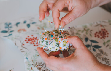 pincushion
multi-colored needles of delicate flowers, fabric and sewing accessories