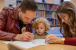 © Connect Images - A child observes intently as two adults focus on writing something on a paper in a library setting. Cleveland, Ohio, USA