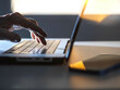 © Connect Images - Man working online on his laptop computer with sunlight coming through window