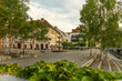 © Connect Images - A scenic European town square at twilight in Ljubljana with Novi Trg Fountain and cobblestone streets, benches, and lush green trees in the old town, Ljubljana, Slovenia