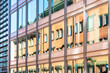 © Connect Images - Reflective glass façade of a modern office building showing distorted reflections of surrounding architecture, Stockholm, Sweden