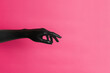 © Anton Tolmachov - Black painted elegant woman's hand on her skin gesticulates on pink background. High Fashion art concept