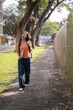 © MINAE - Young asian female student is walking in the university campus, carrying laptop and backpack and laughing out loud, enjoying her time at school