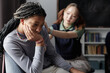 © Seventyfour - Candid portrait of Black teenage girl crying during support group session with caring friend comforting her in blurred background copy space