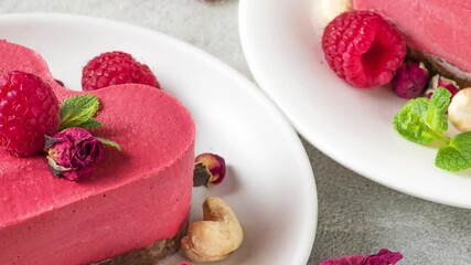 Wall Mural - Valentines day dessert. Heart shaped raw vegan red cakes with raspberries, dried rose flowers and mint. Healthy delicious food. Close up. Love concept