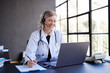 © Rido - Happy female doctor conducting telemedicine consultation at office