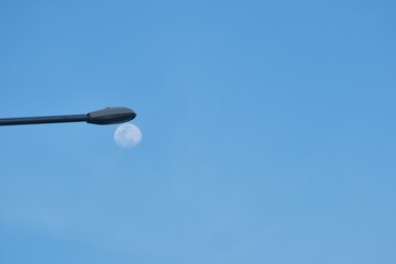 Wall Mural - moon under electric lamp pole on cloud and sky background