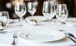 © Resni AI - Empty plate setting on restaurant table with glasses, silverware, and blurred background.