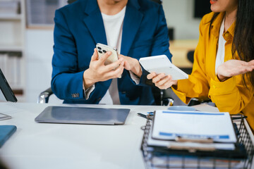 Wall Mural - A businessman and businesswoman are working together at a desk, using a laptop.They are discussing business strategies,financial planning, collaboration to achieve their corporate goals effectively