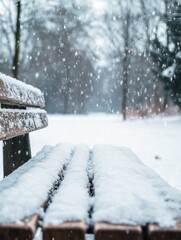 Poster - Snow-covered wooden bench in a tranquil winter landscape with blurred scenery in the background