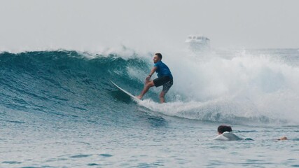 Wall Mural - Surfer rides ocean wave in the Maldives