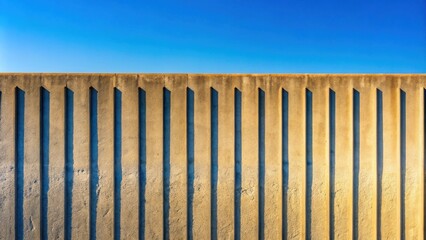 Aufkleber - Abstract Architectural Concrete Wall Design with Vertical Lines and Shadows Against a Clear Blue Sky