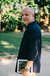 © BullRun - Smiling modern aged man with tablet in park at daytime