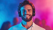 © smth.design - Smiling young Caucasian man wearing headphones in vibrant neon lighting