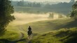 © Safail - A rider on horseback traveling down a dirt path surrounded by green pastures. The morning mist creates a dreamlike atmosphere, and the riders silhouette is illuminated by the soft morning sun