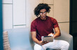 © BullRun - Concentrated cool ethnic man using tablet in reception room
