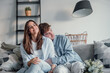 © Daniel - Portrait of young 20s just married couple in love posing photo shooting seated on couch in modern studio apartments, concept of capture happy moment, harmonic relationships, care and sincere feelings.