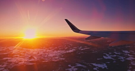 Wall Mural - skyline sunset light, flight with airplane over clouds and land cover in snow