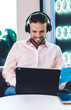 © BullRun - Cheerful professional freelancer in bluetooth headphones enjoying remote lifestyle using modern touch pad for making stock exchange via banking application, happy male searching news and smiling