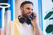 © BullRun - Handsome Caucasian businessman making cellphone consultancy conversation for discussing mobility connection, millennial coworker with bluetooth earphones using smartphone application for talking