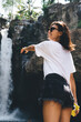 © BullRun - Laughing female tourist enjoying waterfall