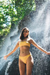 © BullRun - Positive woman standing under waterfall
