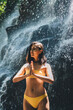 © BullRun - Calm woman meditating near waterfall