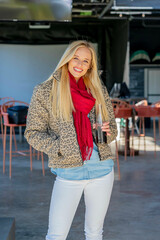 Golden Glow: Stylish Blonde Enjoys Soda and Sunshine at a Bustling Open-Air Mall